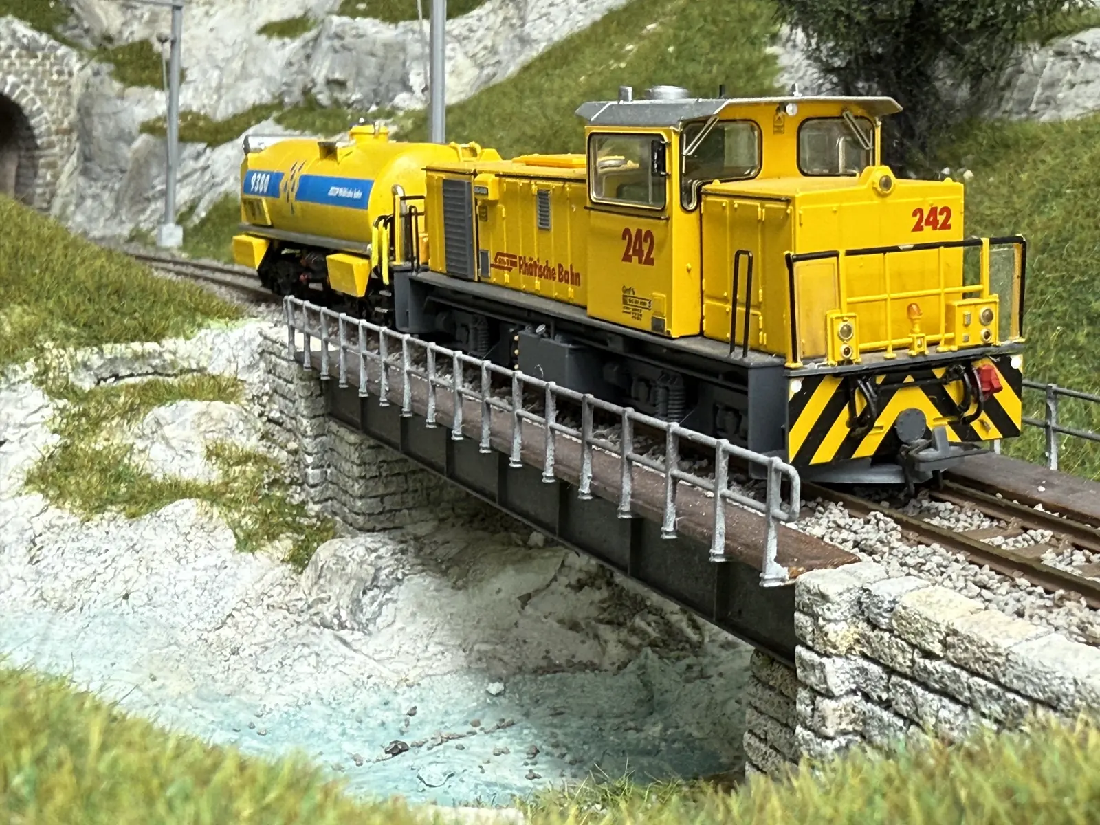 Yellow maintenance vehicle crossing a bridge