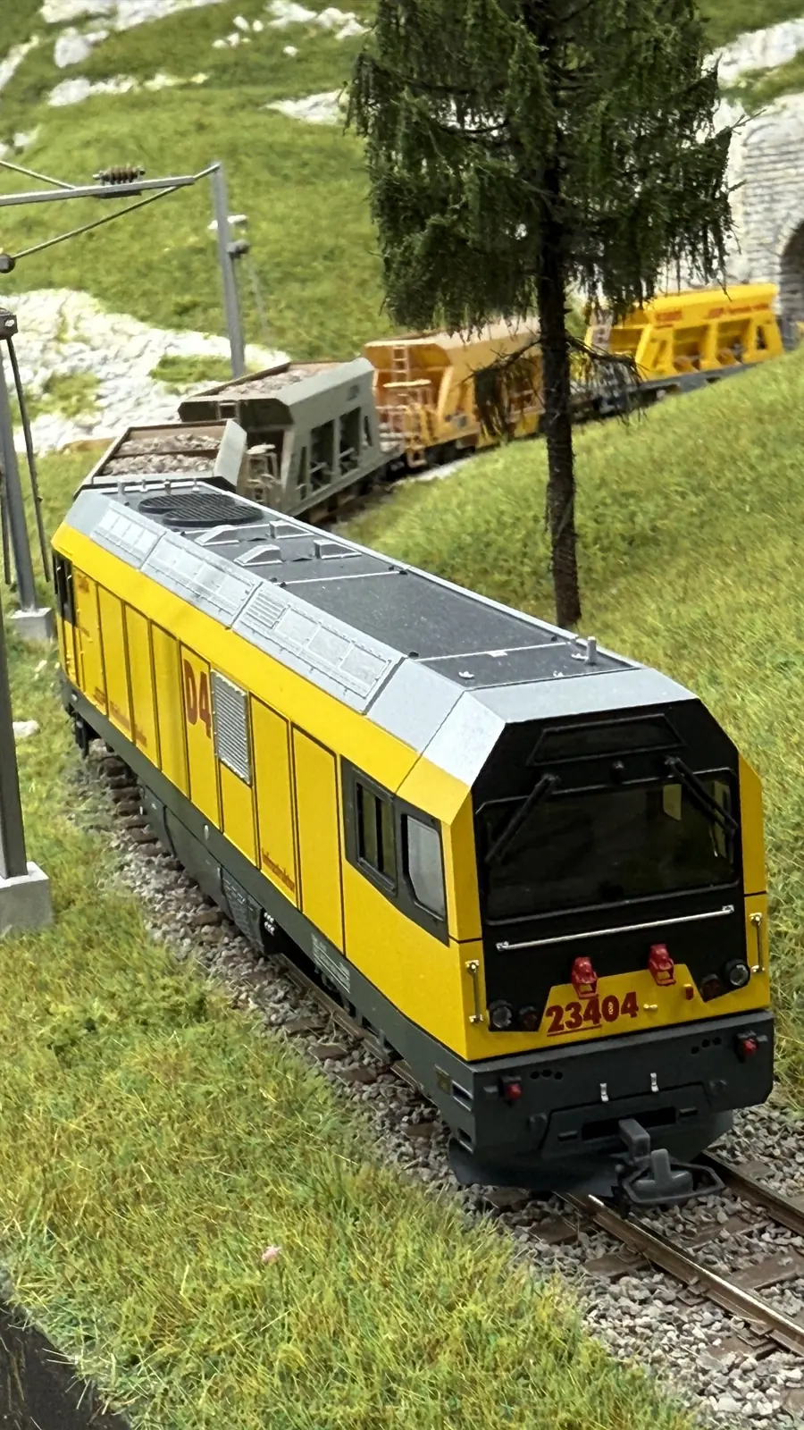Yellow RhB railcar travelling through the landscape