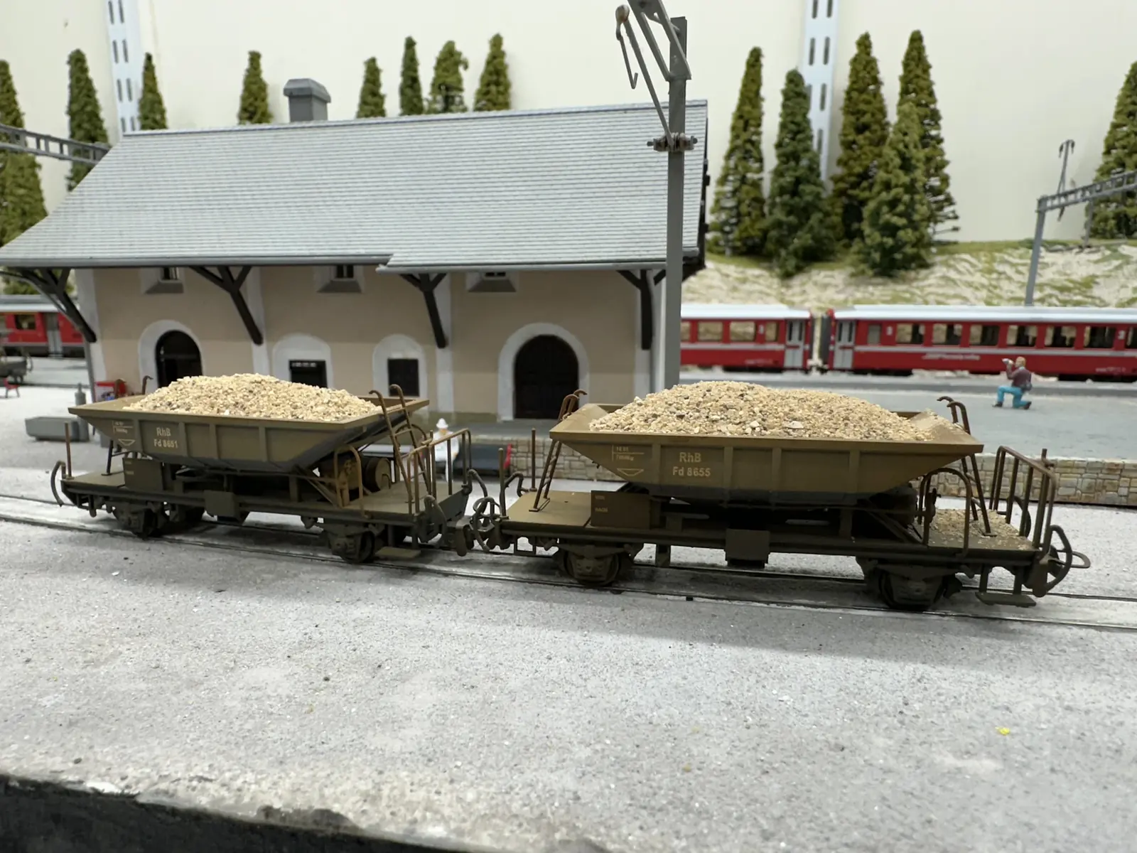 Two 3D-printed early lower-sided RhB Fd hopper wagons loaded with ballast