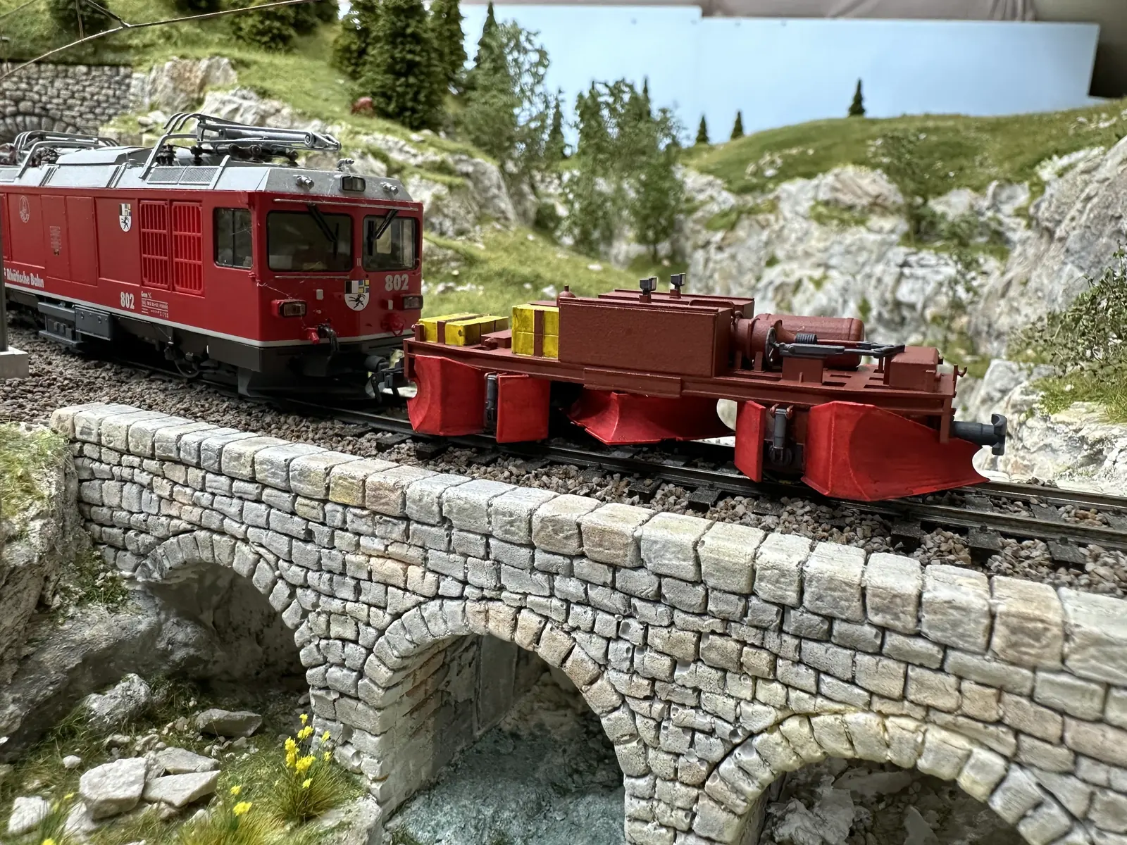 Close view of locomotive 802 and the plough vehicle on a bridge
