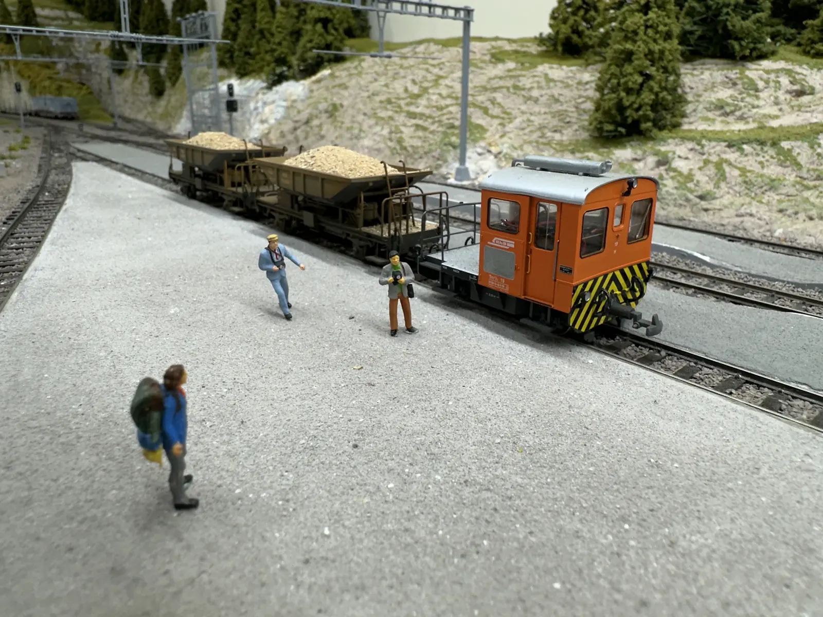 RhB Fd hopper wagons with an orange service vehicle in the yard