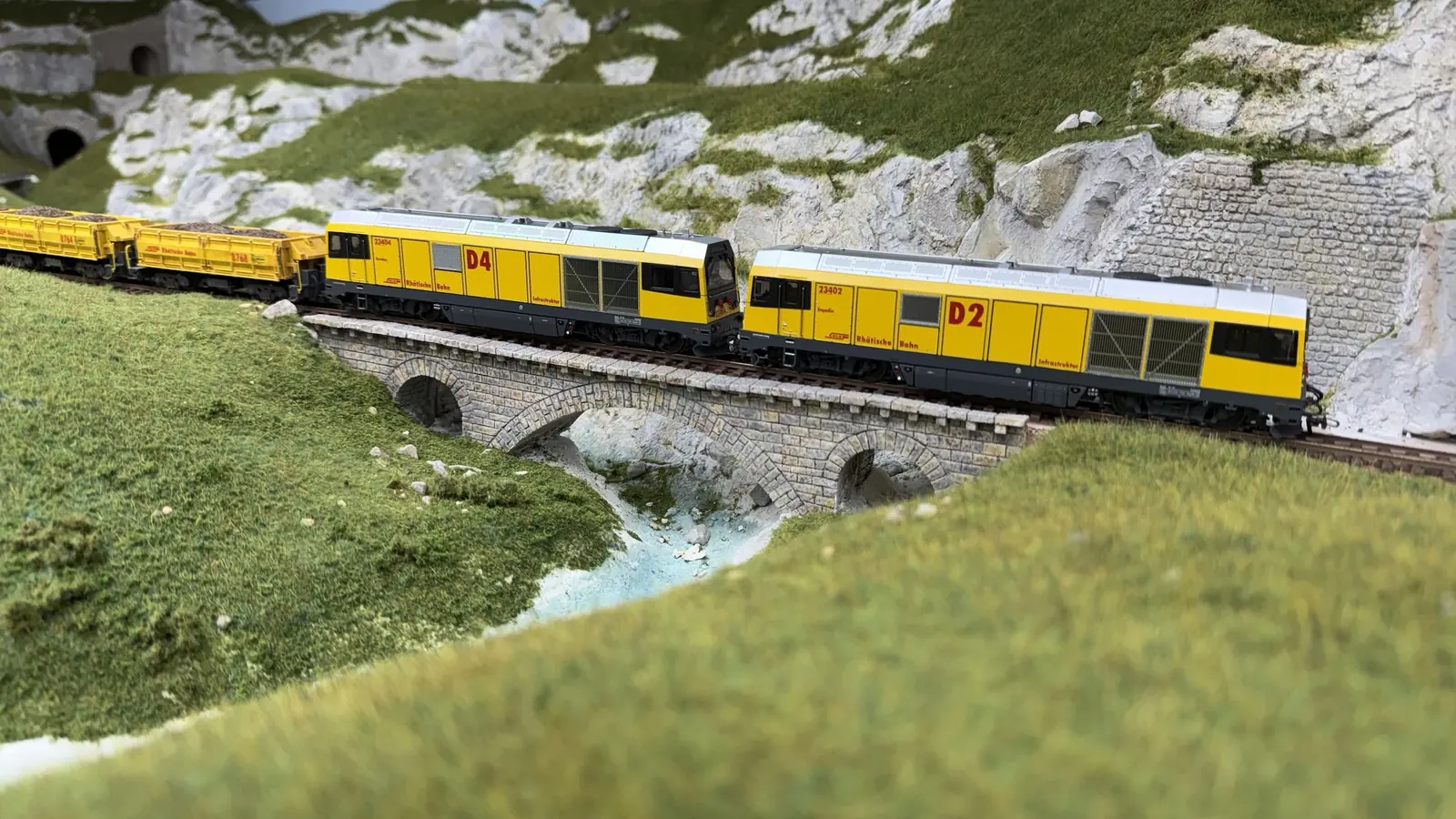 Two yellow engineering units crossing a high viaduct